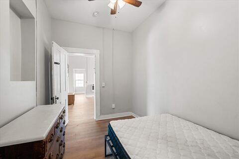 Furnished bedroom with bed and wooden dresser