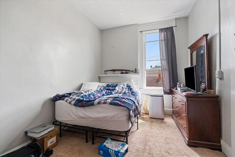 Bedroom with TV, dresser, and full bed