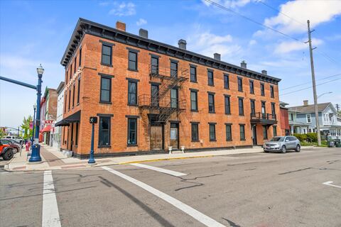 Corner view of the restored three-story brick building and iron fire escape