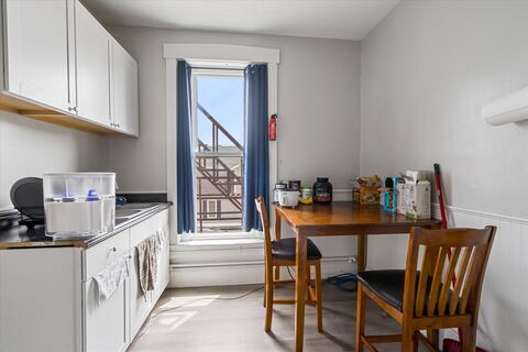 Kitchen with white cabinets and dining table by the window